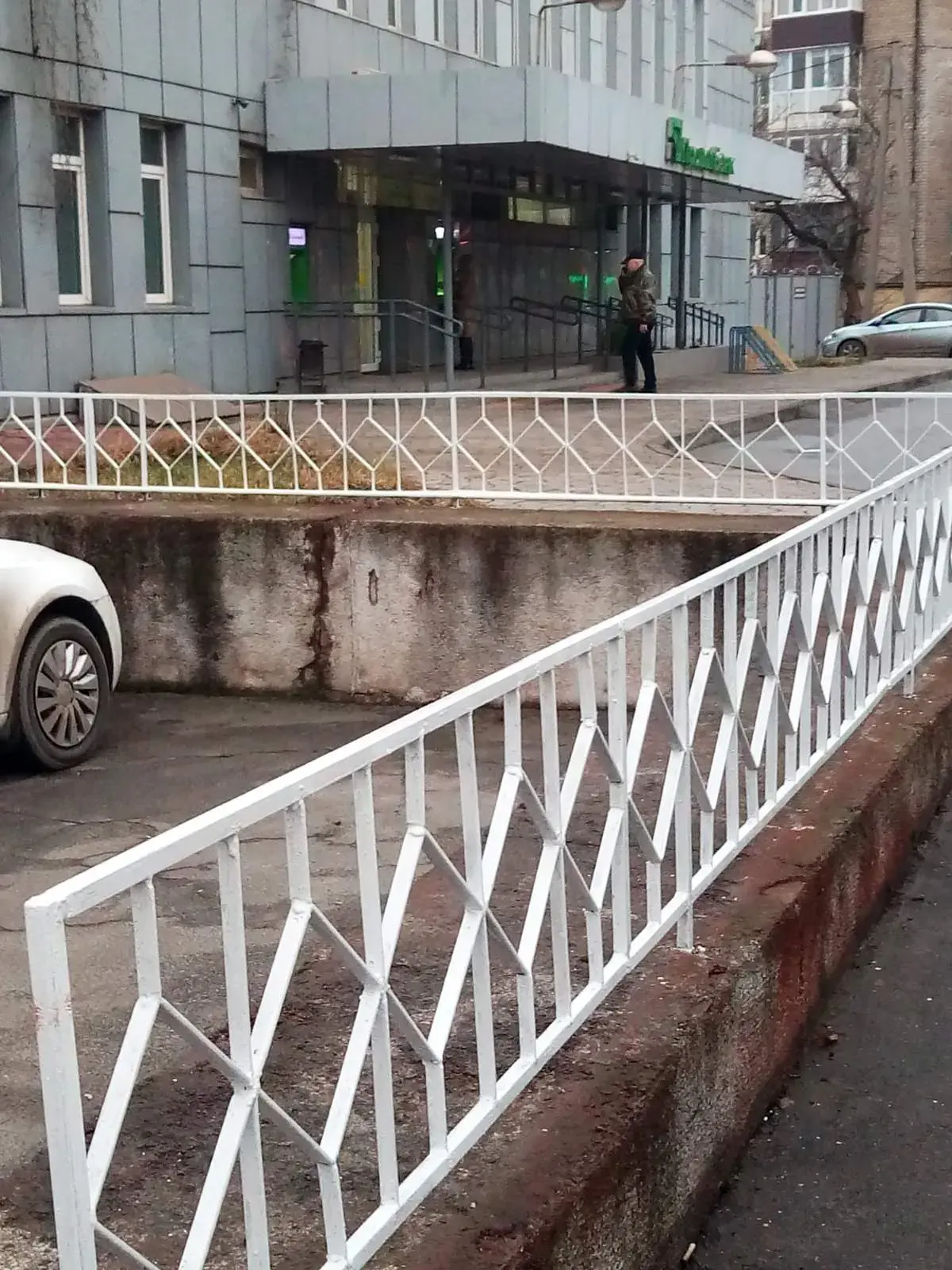 Біла металева огорожа з геометричним заповненням